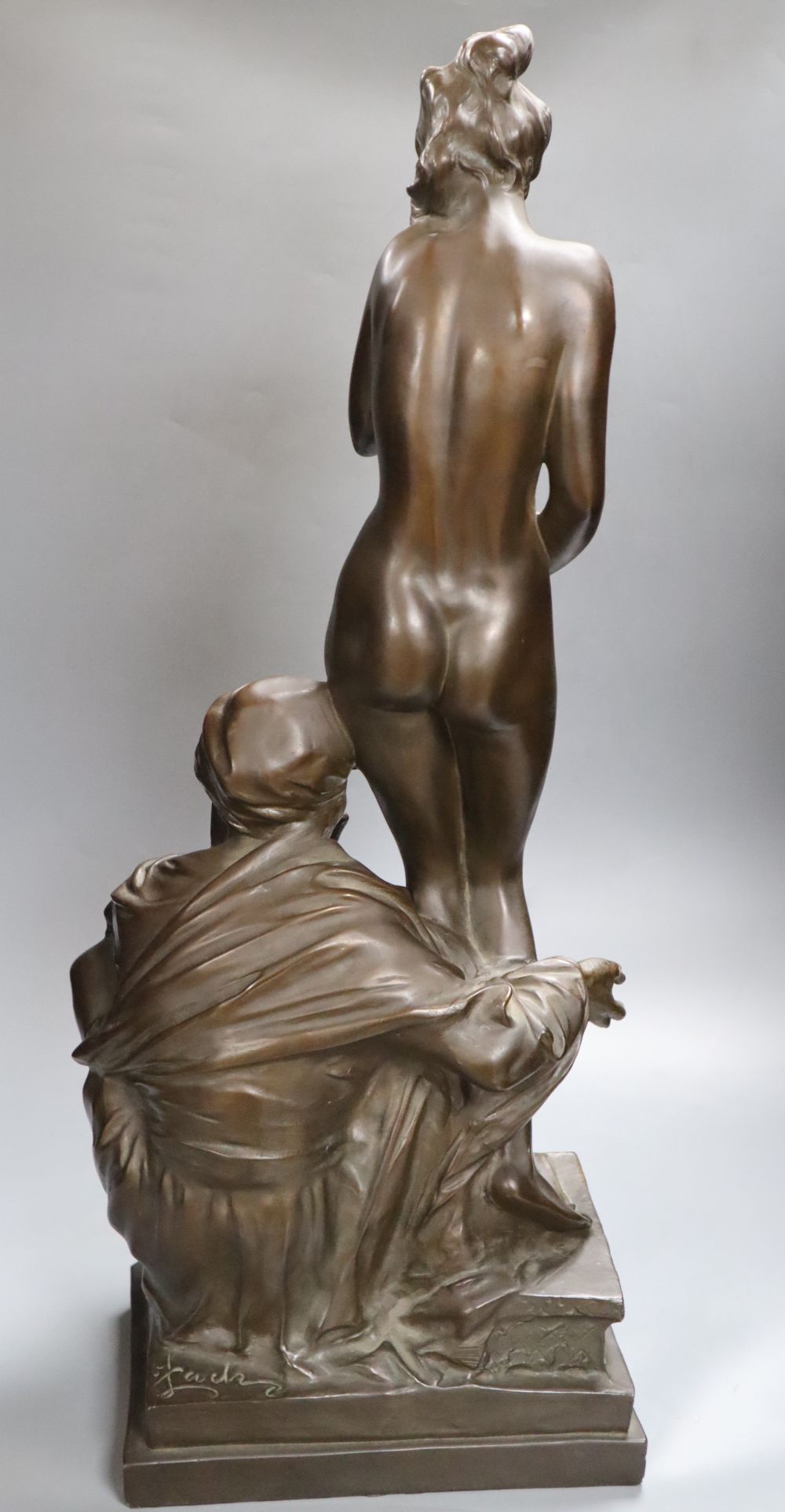 A large bronzed figure group of a seated male and nude female, indistinctly signed, 66cm